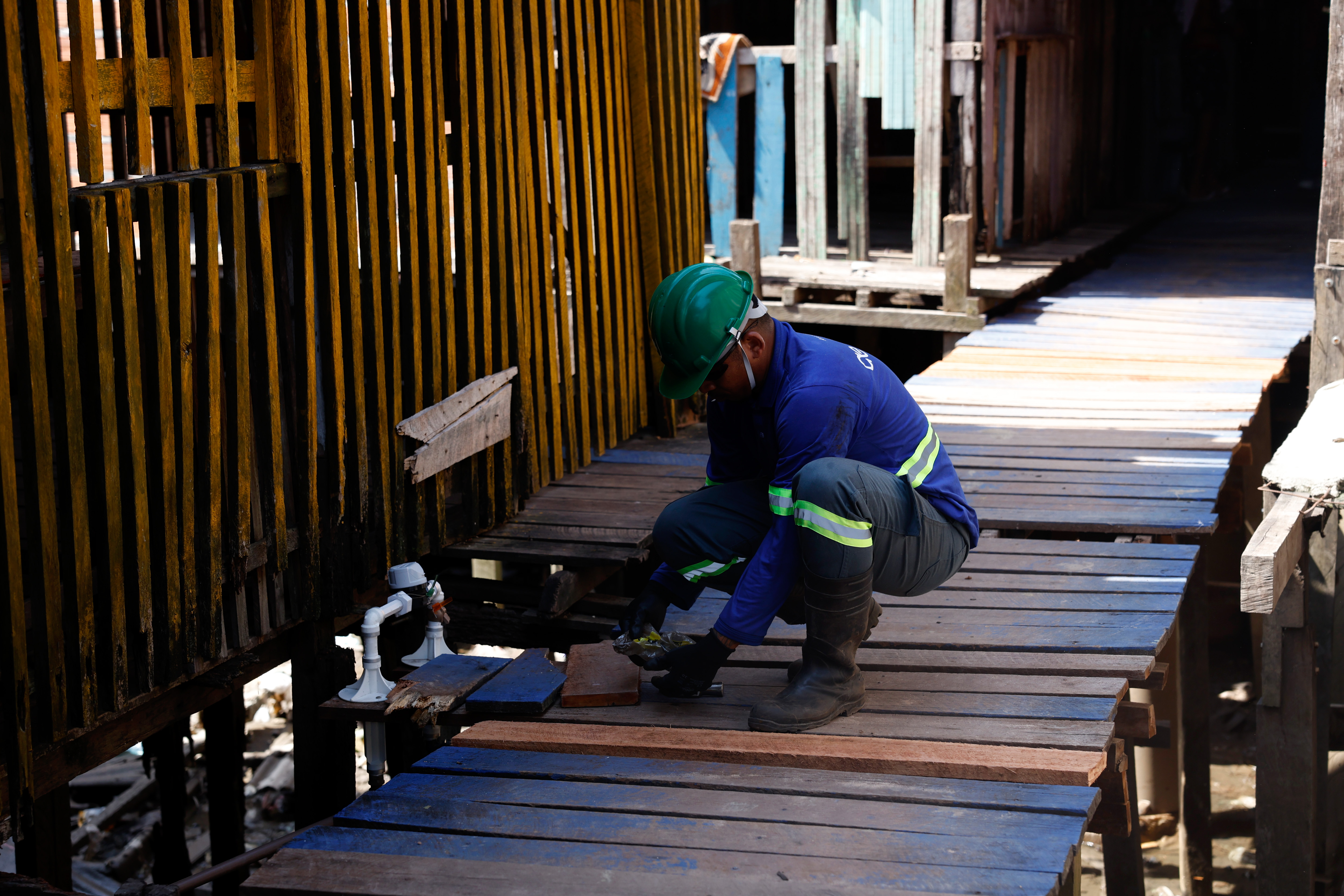 Belém (PA), 18/11/2025 - Funcionários da Águas do Pará trabalham na distribuição de água encanada na comunidade da Vila da Barca, erguida em construções de palafitas na baía do rio Guajará.